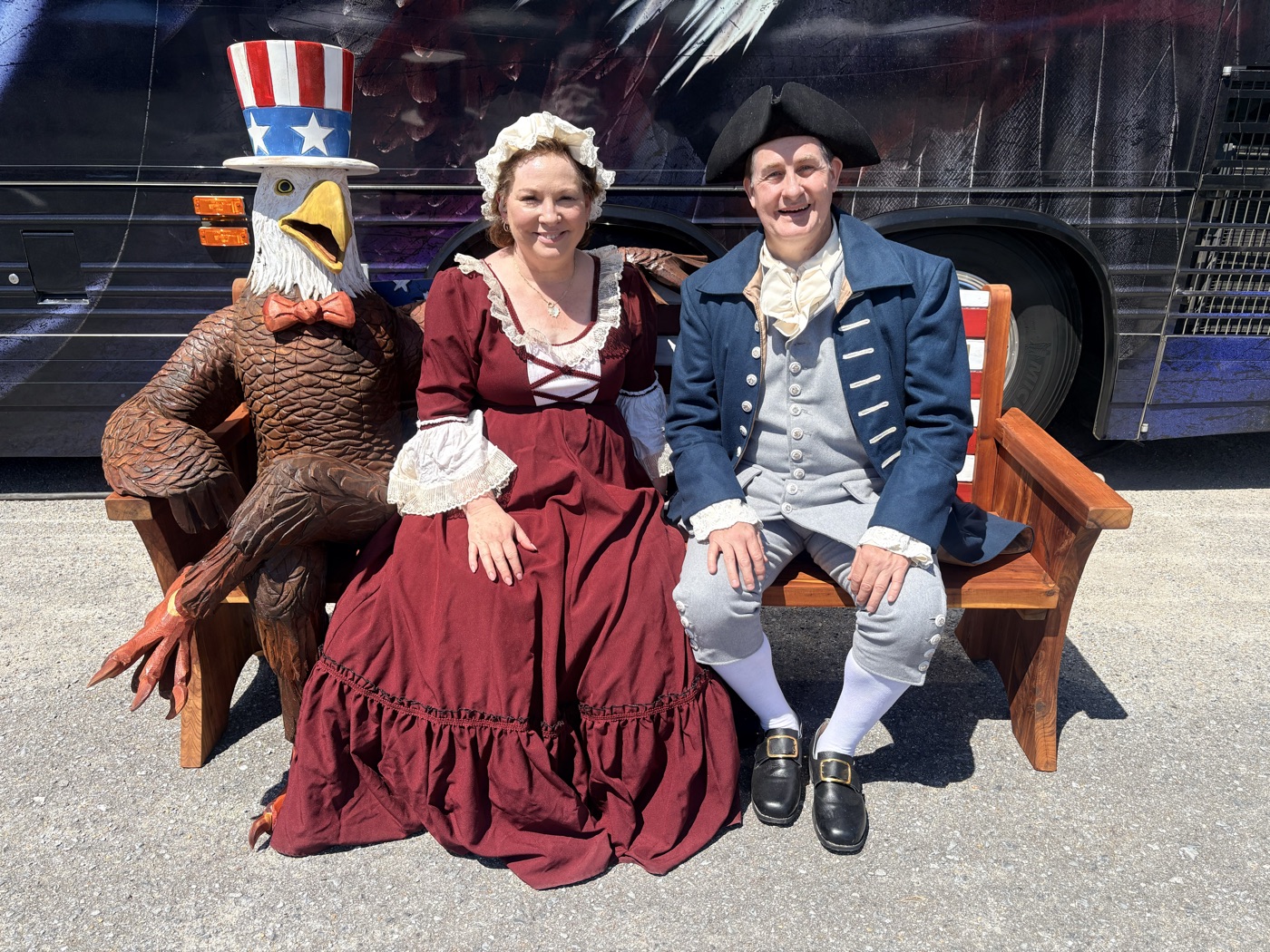 Colonial reenactors seated by the eagle tour coach